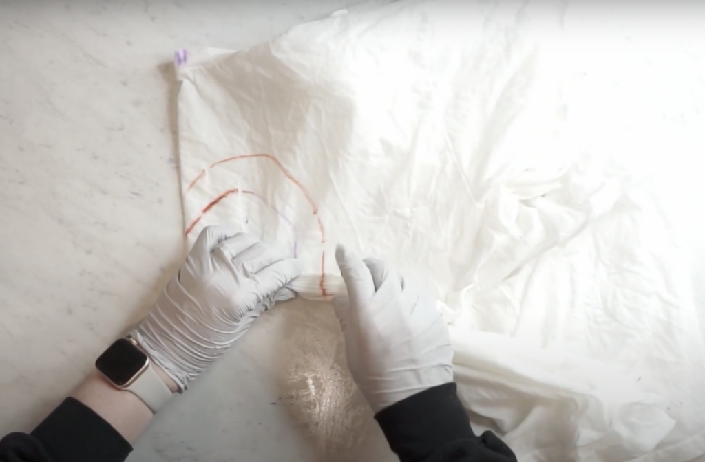 Accordion folding the heart line on a shirt before tie dyeing